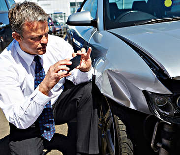 Verkehrs-Rechtsschutzversicherung - Mann fotografiert Blechschaden an Auto