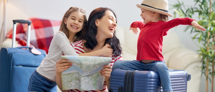 Ratgeber Koffer packen - Mutter packt Koffer mit zwei Kindern